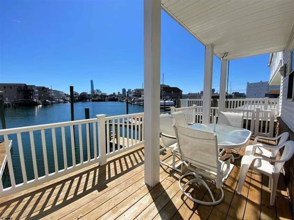 Lower deck with boat slip access and outdoor dining.