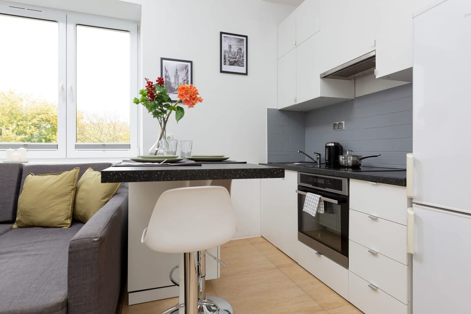 The functional kitchenette space with white cabinets and top-quality appliances allows you to prepare home-cooked meals.