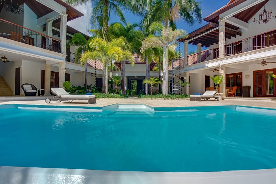 Large pool area with outdoor living, lanai with alfresco dining, next to beach.