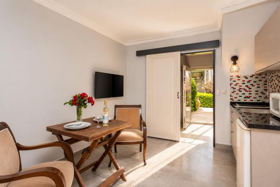 Open-plan living room with dining area, kitchen, A/C, WiFi internet, satellite TV, and pool terrace access