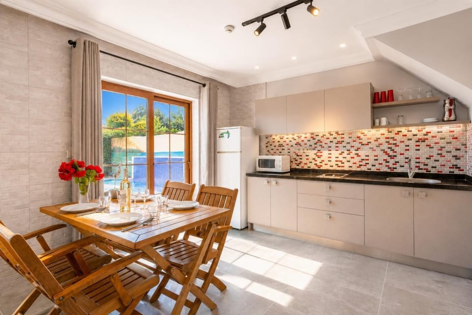 Open-plan living room with sofa, dining area, kitchen, A/C, WiFi internet, satellite TV, and terrace access