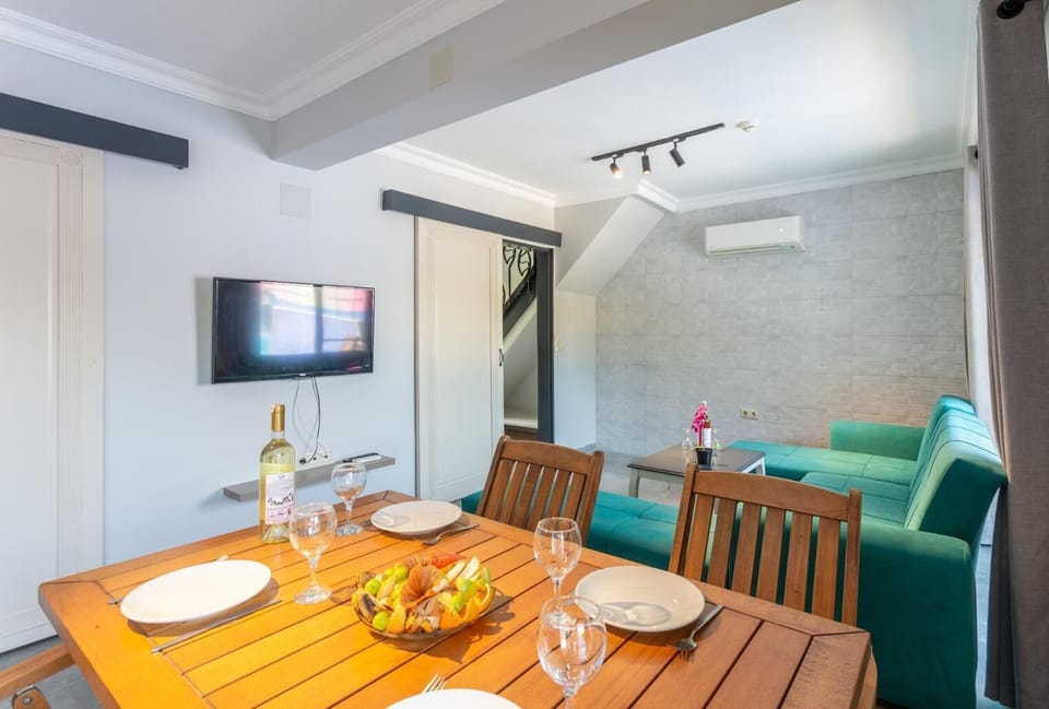 Open-plan living room with sofa, dining area, kitchen, A/C, WiFi internet, satellite TV, and terrace access