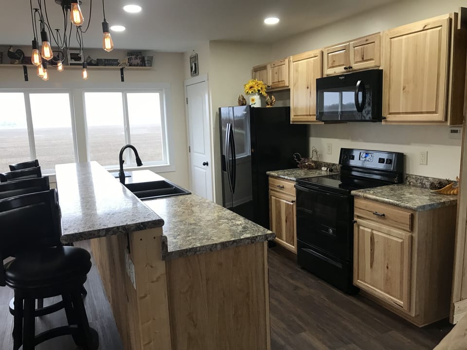 Loft kitchen has dishes, silverware, pots and pans,  napkins, and some condiment