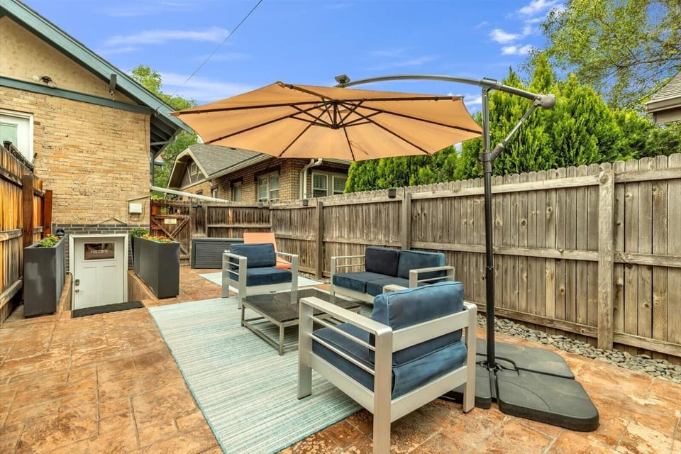 Private fenced patio with shaded seating and stylish outdoor lounge area