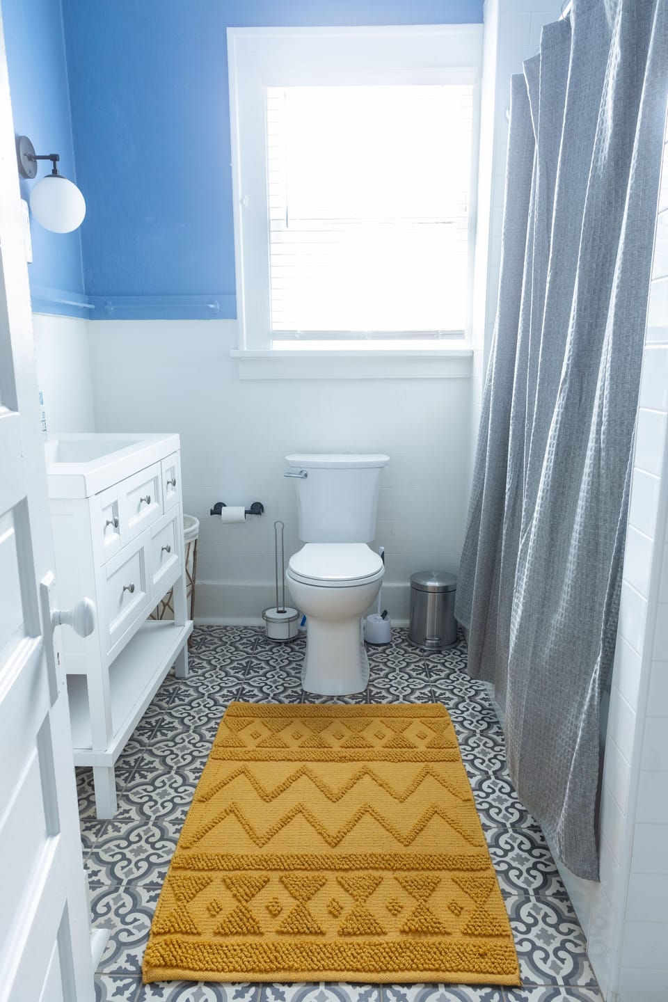 Sunny bathroom with classy Spanish floor tile and sleek vanity