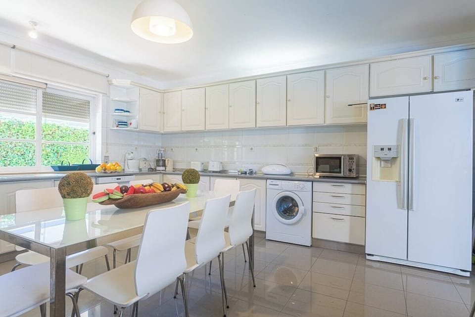 Modern white kitchen with dining area and appliances — Villa Niki, holiday villa in Grândola