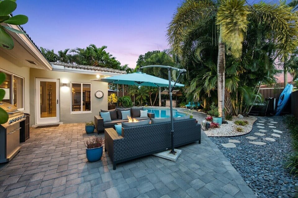 Relax in the private backyard with amazing day and nighttime views and amenities that include a heated pool, 6 person hot tub, outdoor shower, outdoor fire pit with lounge seating, umbrellas for shade, pool chaise lounge chairs, BBQ grill and comfortable dining seating under shade all surrounded by tropical landscaping.