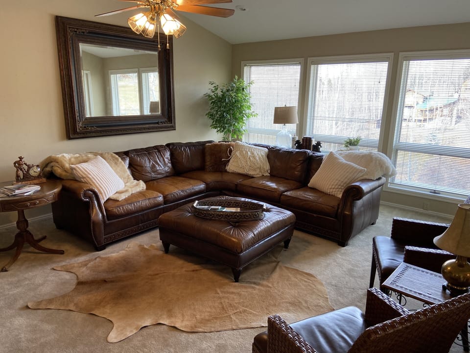 Living room with walk out. Large tv and leather sectional for big group. 