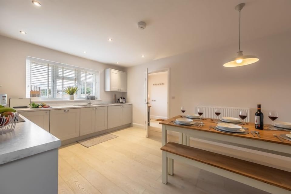 The kitchen has a large dining table with benches