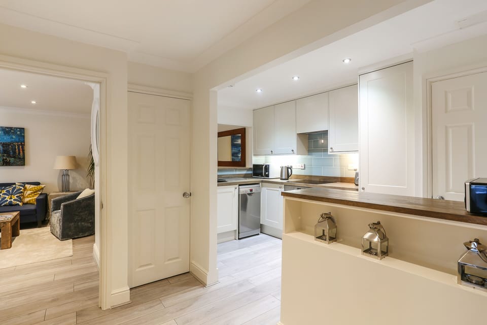 Open plan hallway with Washer/Dryer laundry machine in cupboard.