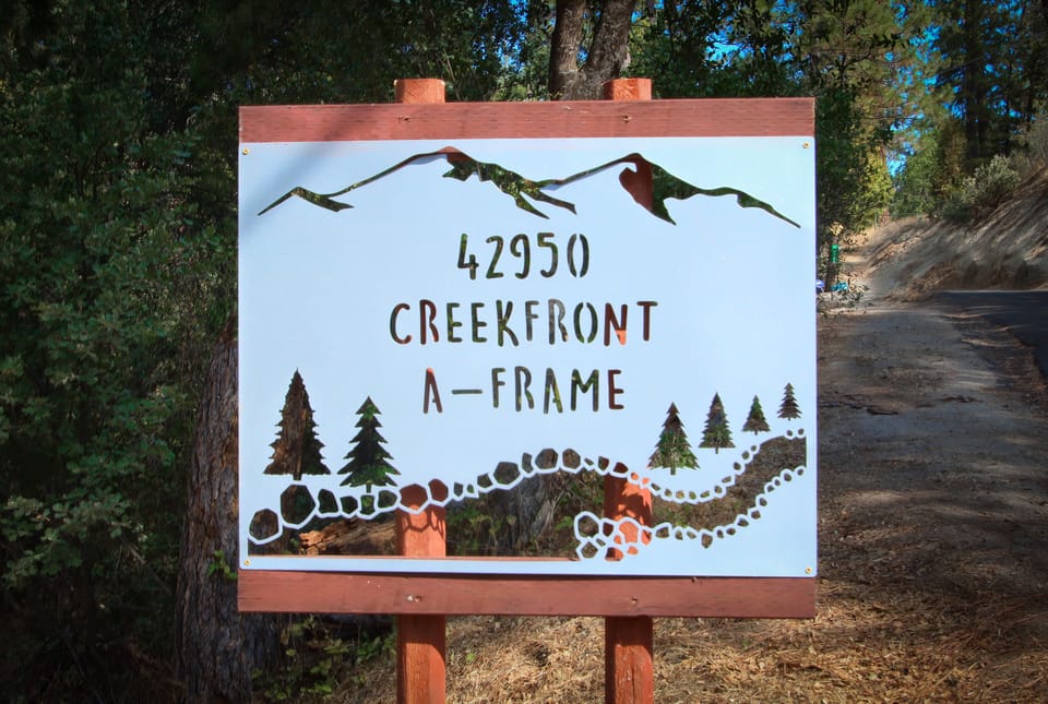 Creekfront Property signboard marking the entrance to a serene retreat.
