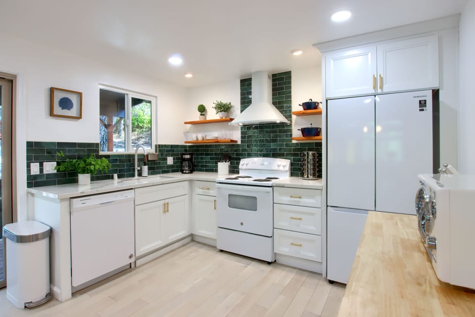 Bright, inviting kitchen with white appliances and sleek countertops.