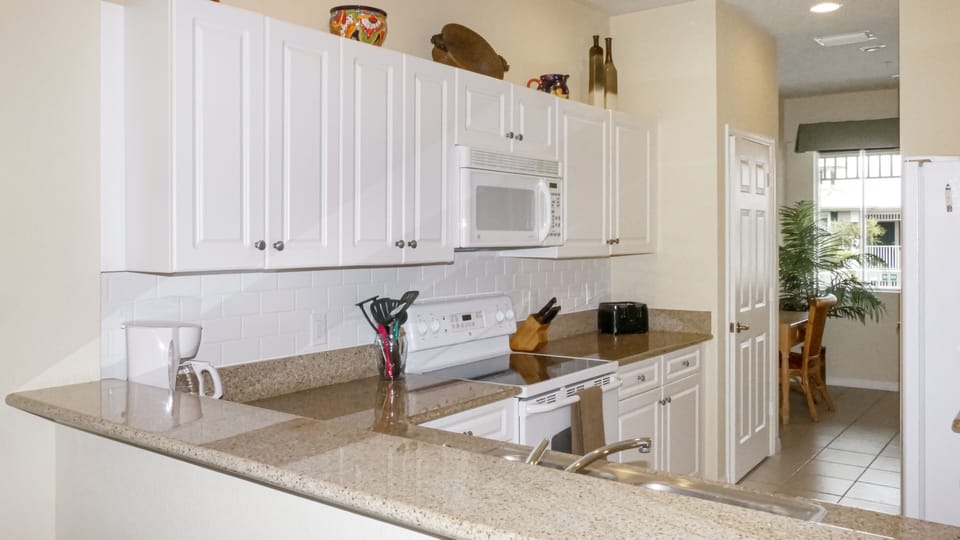 Well equipped kitchen with granite counter tops.