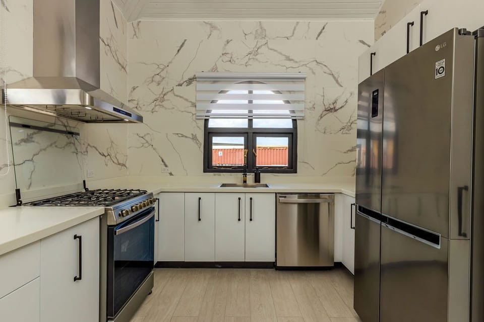 A modern and fully equipped kitchen welcomes you. Complete with a stove, oven fridge, and in the center, you can see the spectacular chandelier that creates the mood.