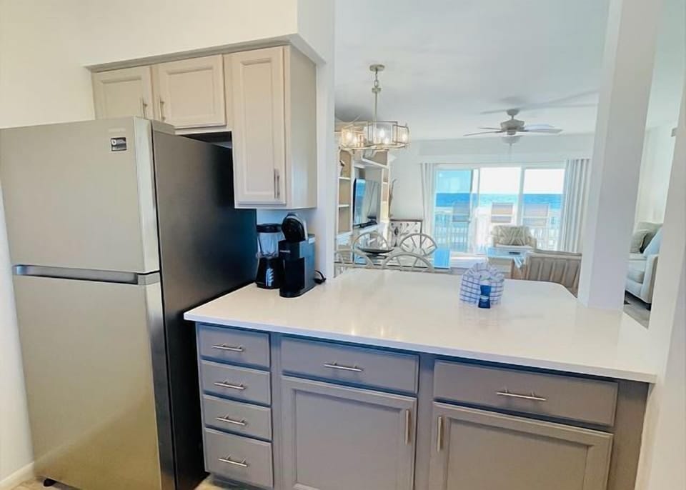 Your fully equipped kitchen overlooks stunning ocean views, perfect for preparing meals while watching the waves dance outside your window.