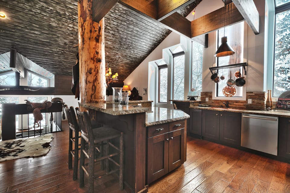 Additional seating at the breakfast bar in the kitchen in log style barstools