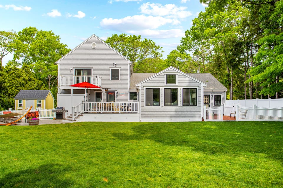 Large fenced in back yard with firepit, deck, and patio.