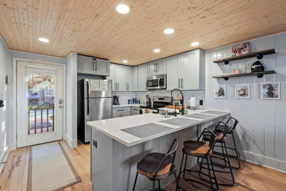 Kitchen Harmony: The fully equipped kitchen and kitchen bar seating area seamlessly connect to the inviting living room, creating a harmonious setting for countless memorable evenings.