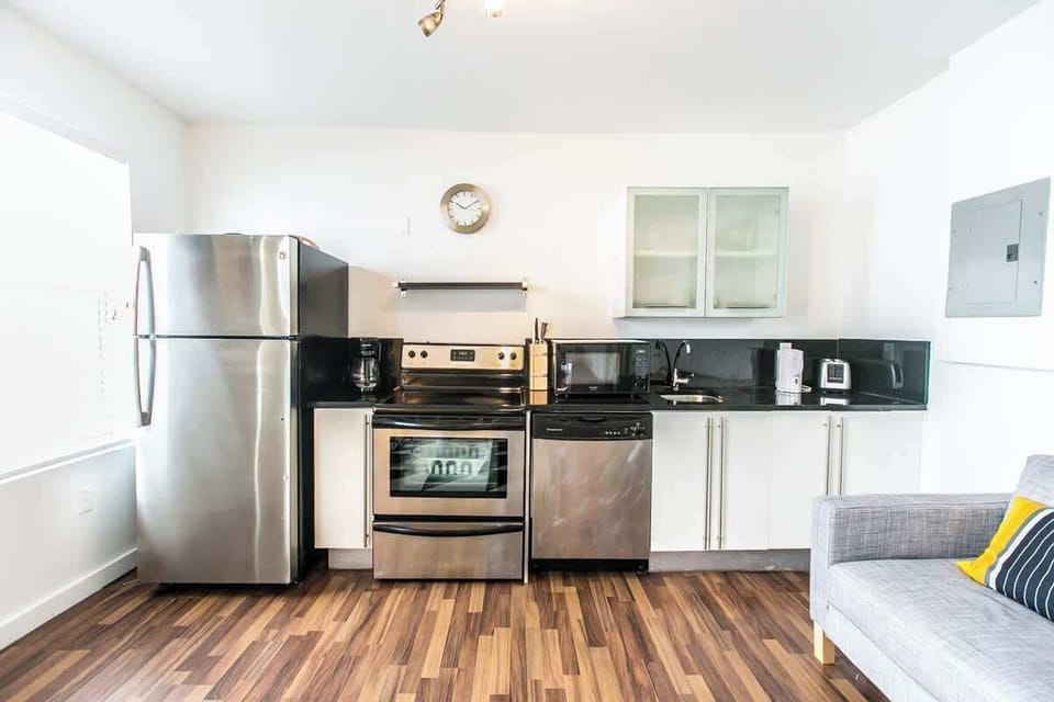 Cook and dine in this sleek space with stainless appliances, geometric rug, and stylish seating.