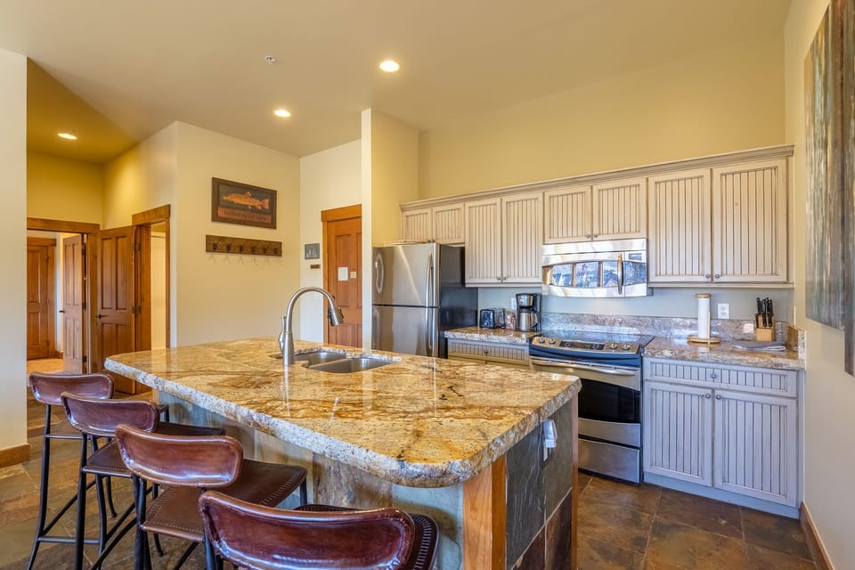 Kitchen, hallway to queen suite, hall bath, and queen bedroom in left of photo