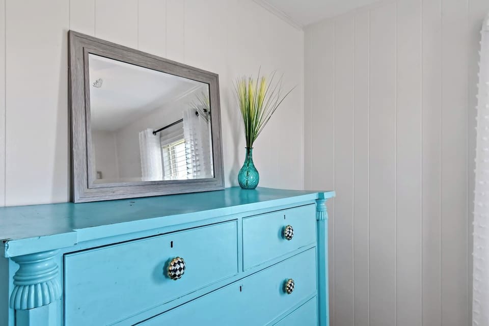 Bright blue dresser and airy decor create a refreshing vibe!