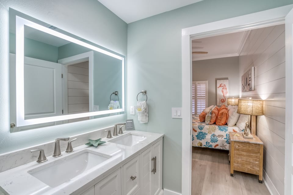 Private spa-style bath with double sinks, LED mirror & elegant coastal design 