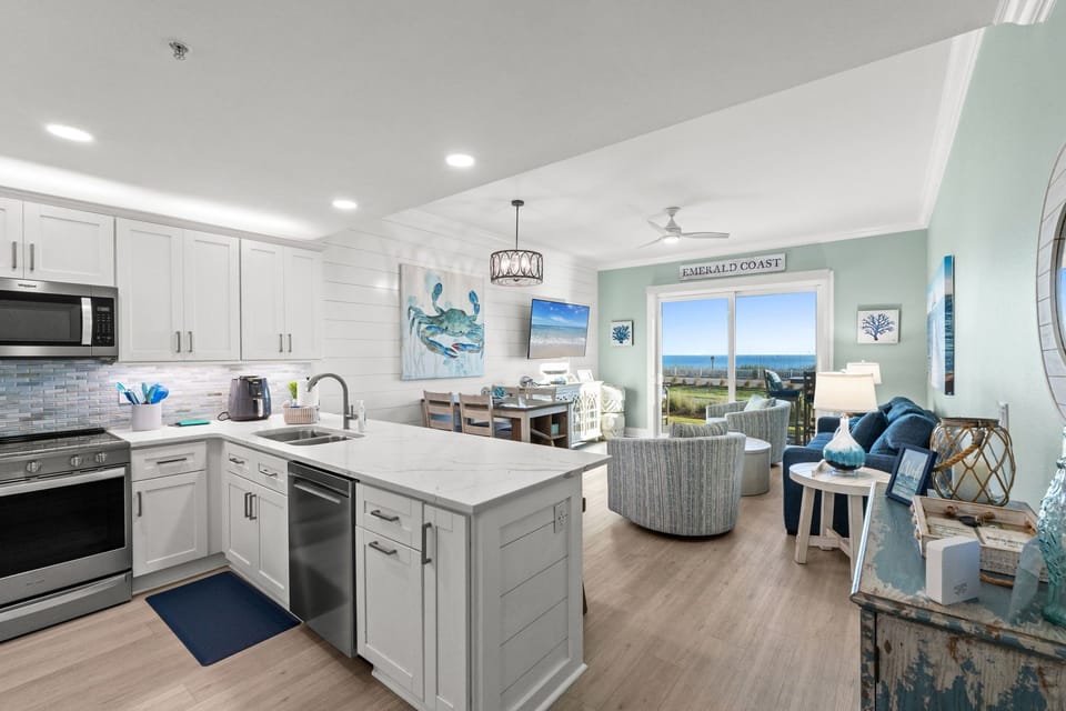 Bright modern kitchen with quartz counters, island seating & ocean views.