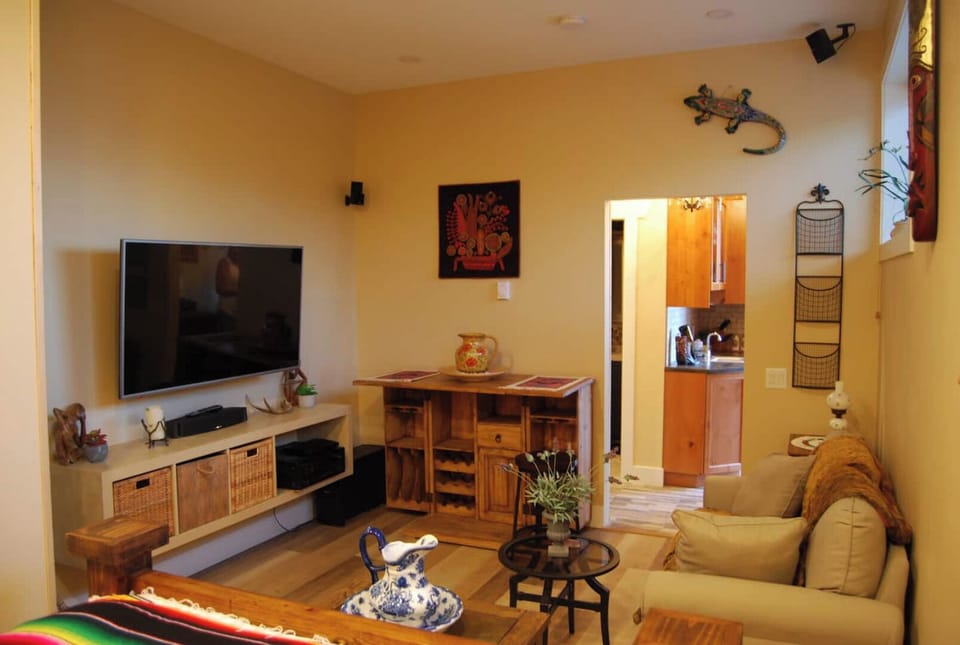 Guests living room with TV and stereo. Opening eating nook with two stools.