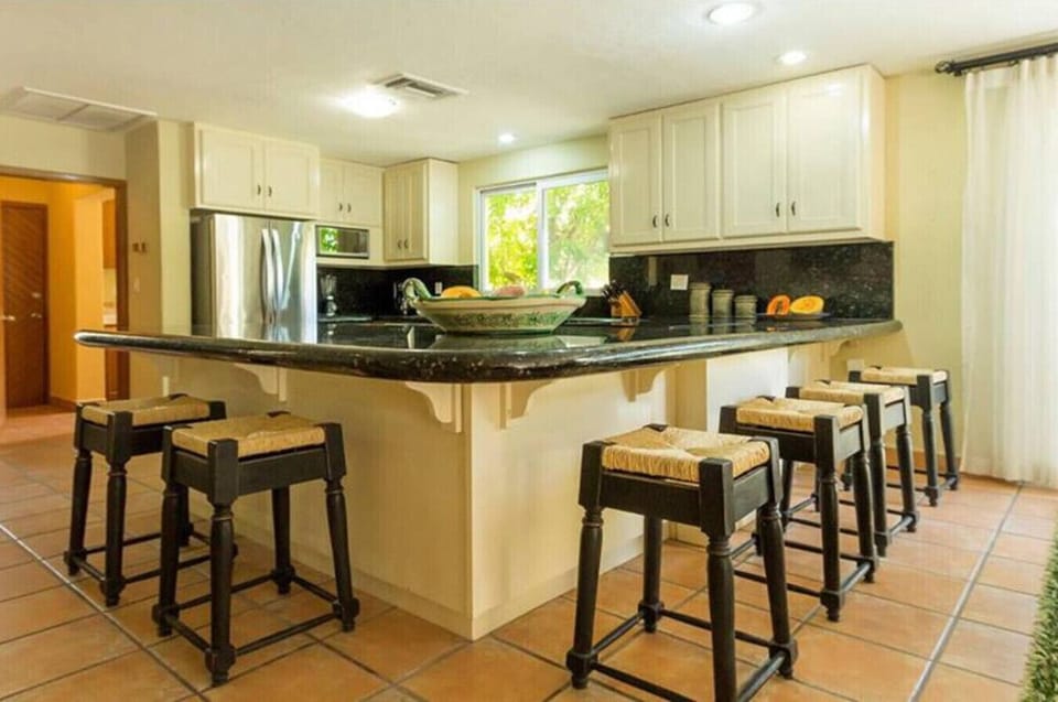 A spacious kitchen with sleek granite counters and seating for six, perfect for family meals.