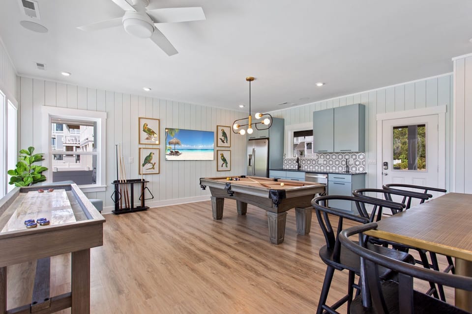 Ground-level game room with pool table, wet bar, full-sized refrigerator, and dishwasher for fun-filled entertainment.