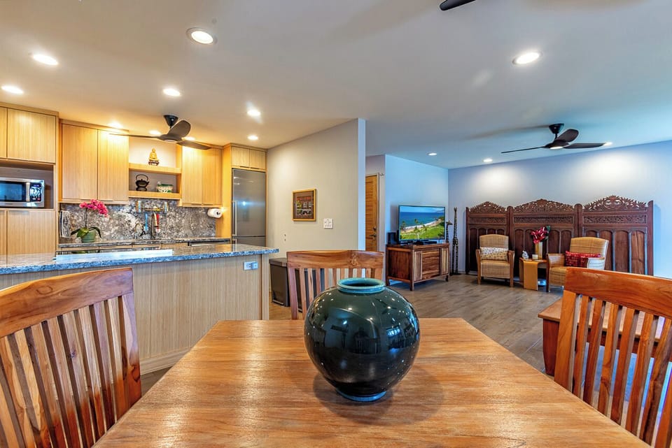 Open, roomy living area with solid teak dining table and chairs.