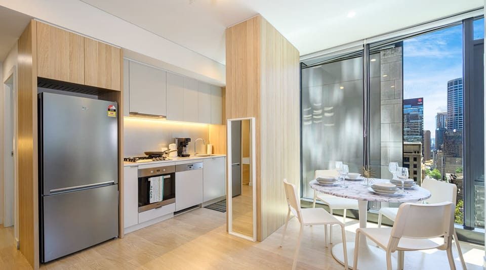 Modern kitchen with fridge, oven, cooktop, and cabinetry.