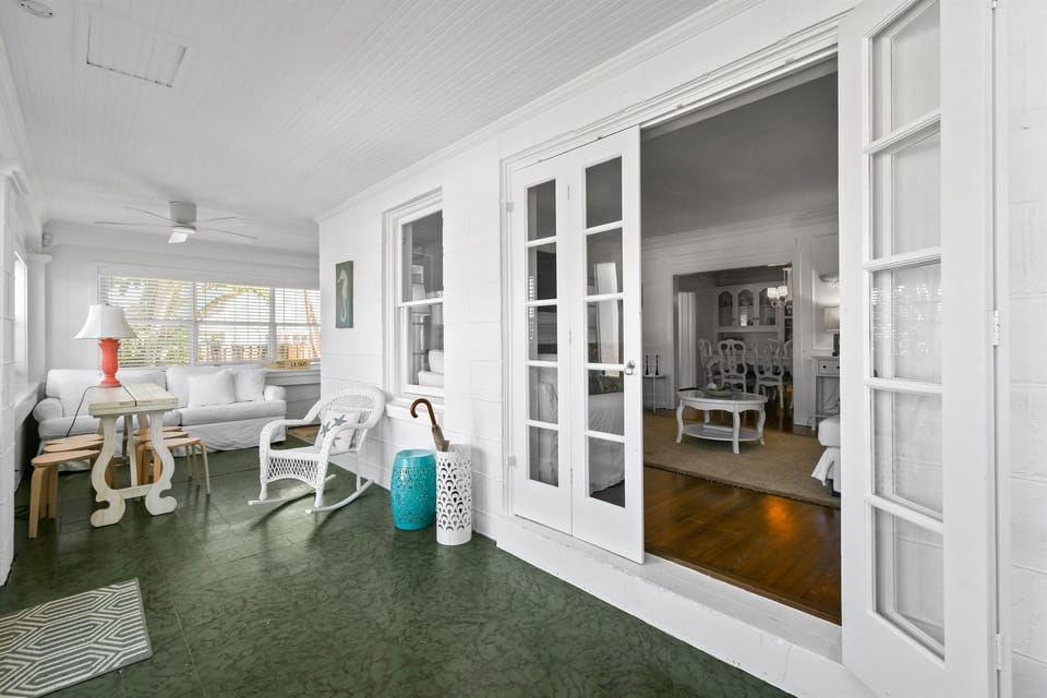 Enclosed Front Porch: Wrap-around seating, dining areas, coffee station, string lights.