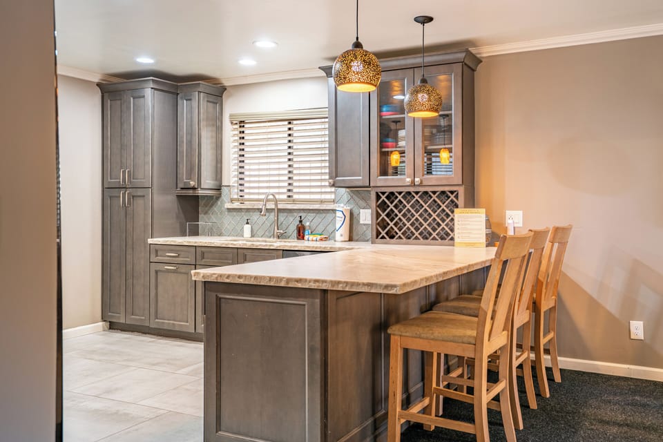 Kitchen's barstool seating with pendant lighting.