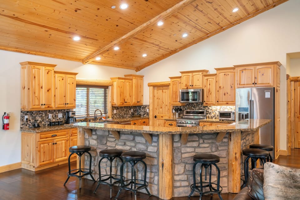 Kitchen features a large island, breakfast bar and modern appliances.