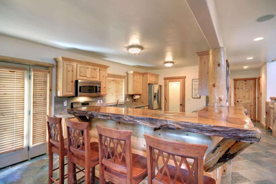 Kitchen features modern appliances and barstool seating.