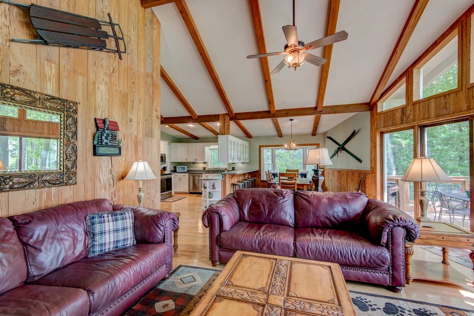 Kick back on leather sofas beneath soaring beamed ceilings, with the kitchen and wooded views just steps away.