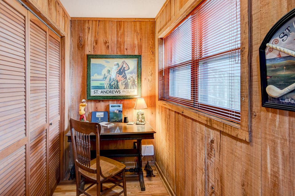 A cozy wood-paneled nook, with a vintage desk and classic art to set the mood.