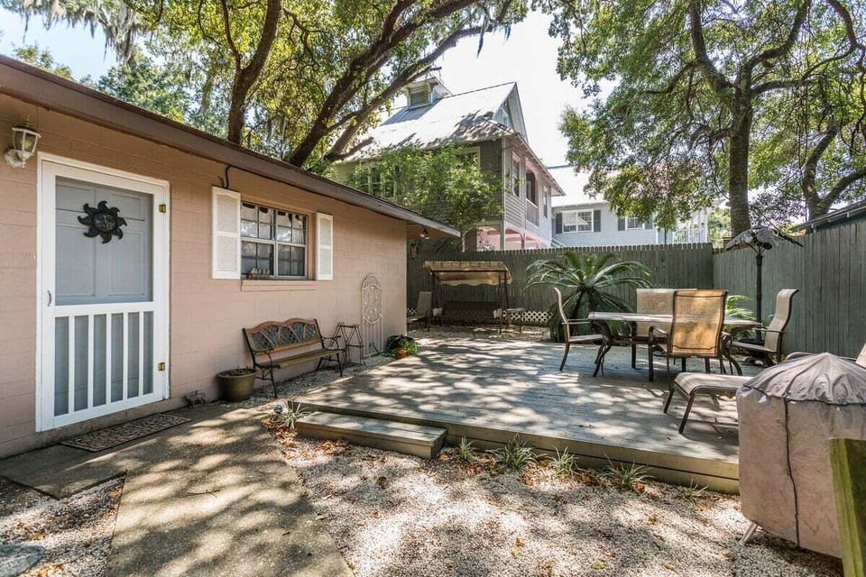 Rear exterior patio with seating under large trees