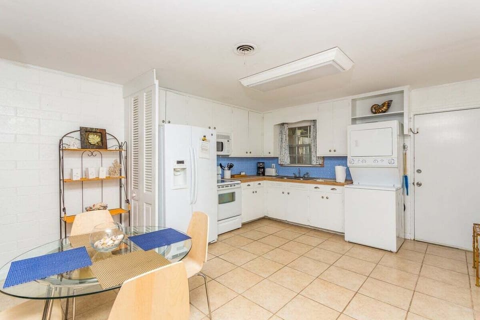 Open kitchen and dining area with white appliances and shelving