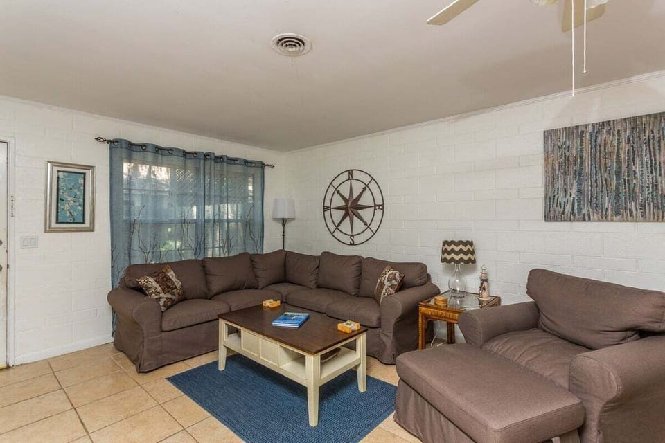 Living room with sectional, compass decor, and blue rug