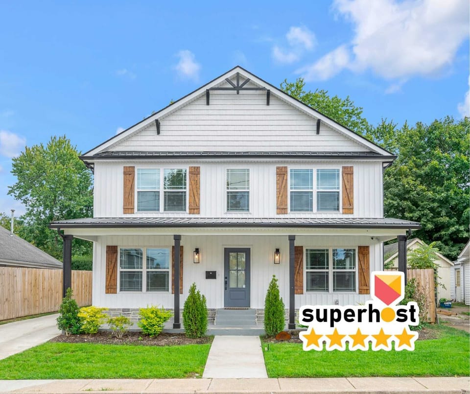 Welcome to the front of our newly constructed farmhouse, showcasing modern design with classic charm. Enjoy the inviting entryway, beautiful landscaping, and warm ambiance that set the tone for a relaxing stay.