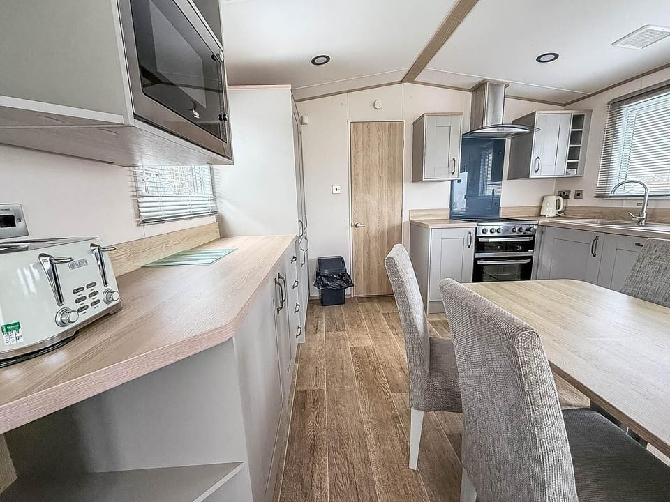 Prepare your favourite UK holiday meals while still being part of the conversation in this convenient open plan caravan kitchen.
