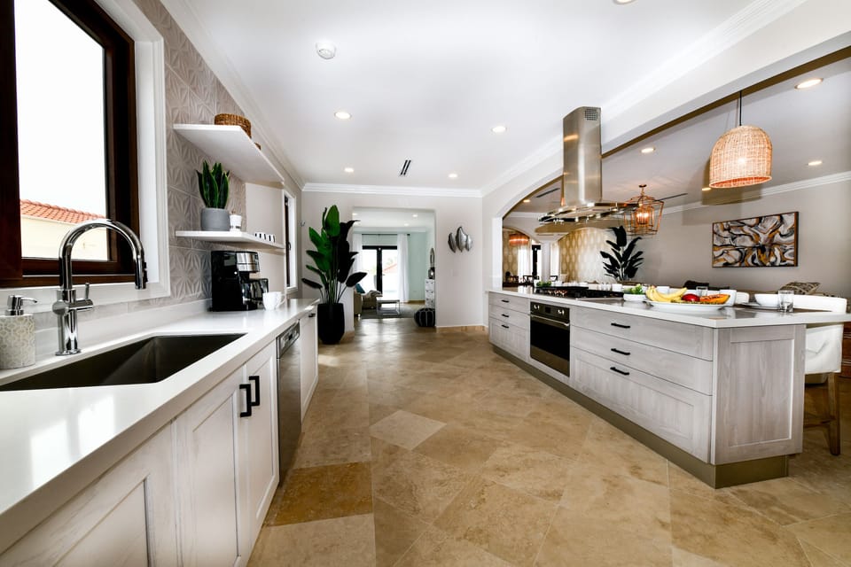 Spacious Kitchen Area of the Villa in Noord Aruba - Modern kitchen with sleek, stainless steel appliances - Contemporary design with clean lines and minimalist aesthetics - Smart use of space with versatile storage solutions