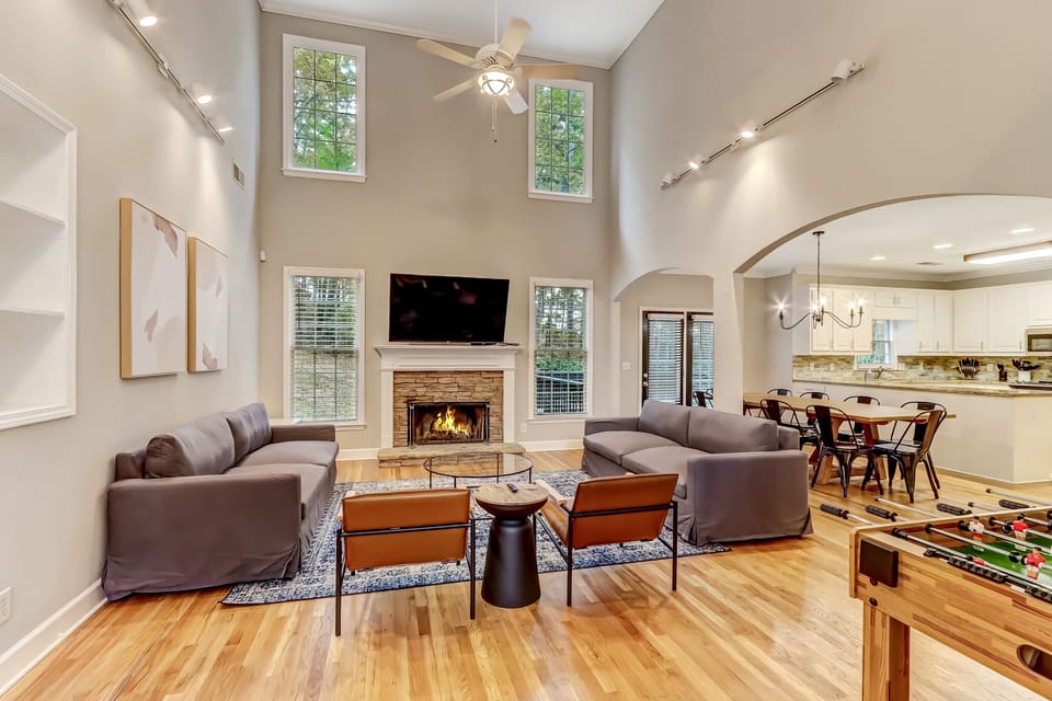 Living room feat. 65" Roku Smart TV, plush seating, and foosball table