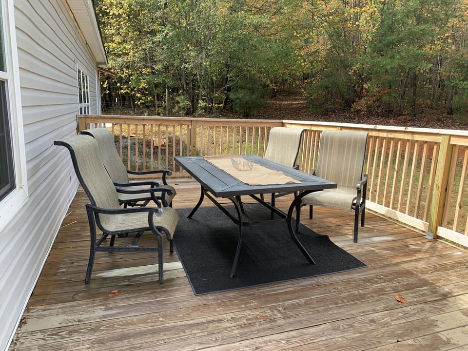 Back deck with full sun. View of backwoods.