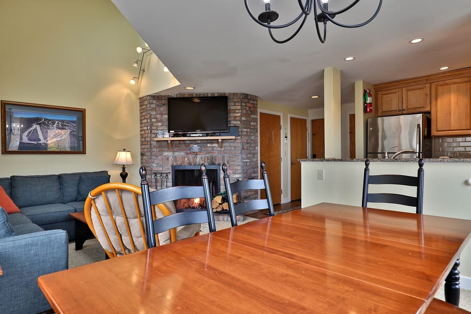 Dining, living room with wood burning fireplace and kitchen area