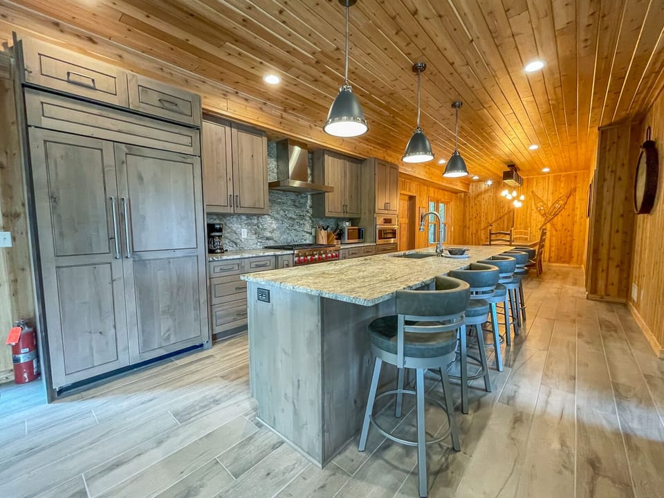 The home has a spacious chef's kitchen complete with a 6-burner range and a refrigerator and dishwasher that blend in with the custom cabinetry.