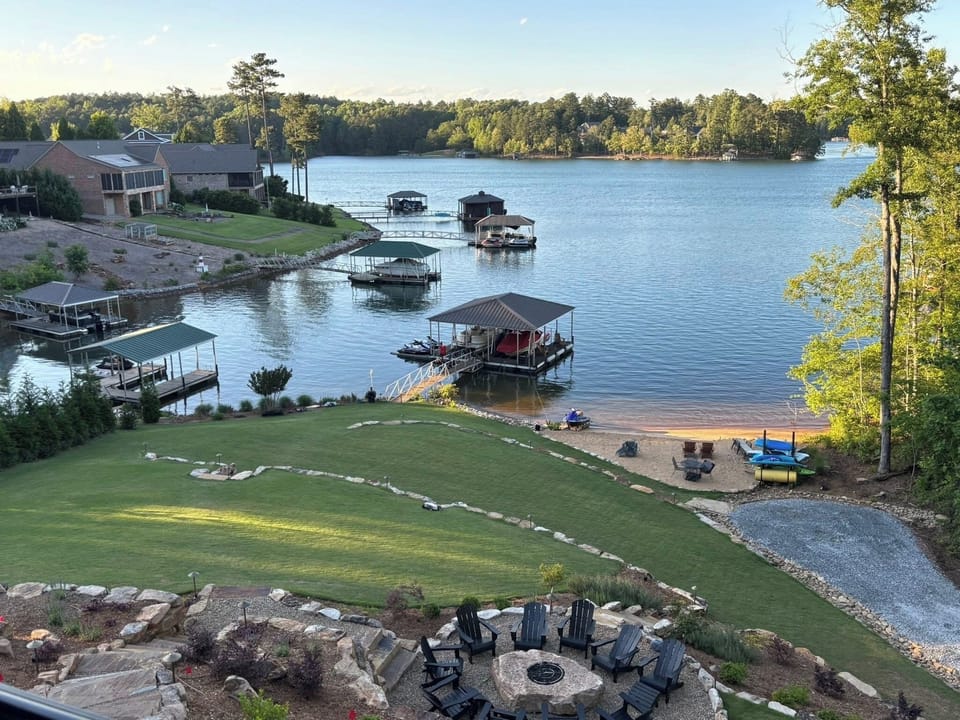 Huge backyard w/ private sandy beach, dock, & gas fire-pit overlooking the lake.