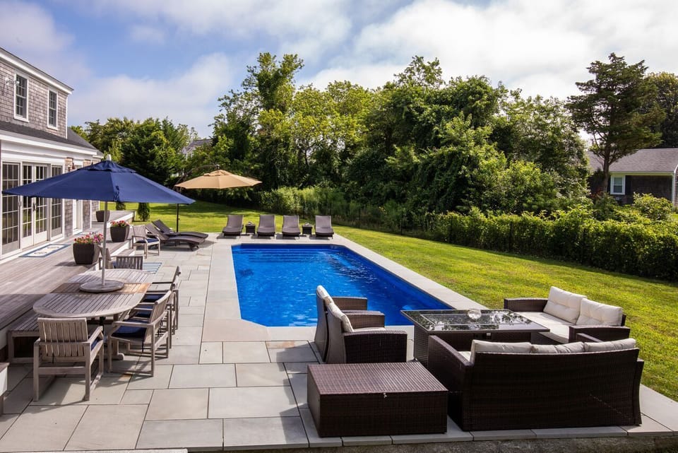 View of the pool, fire table and outdoor dining table for 10.